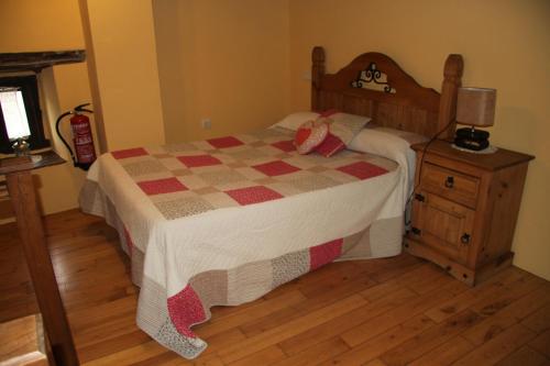a bedroom with a bed with a checkered quilt at Ca María Santa in Proaza