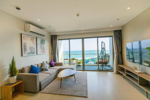 a living room with a couch and a large window at The Song Luxury Apartment Vung Tau - Siêu ưu đãi chỉ có trong tuần nay in Vung Tau