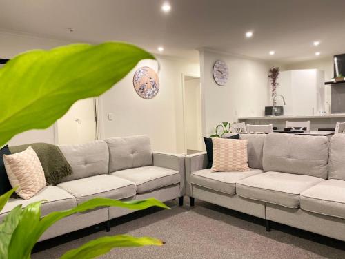 a living room with two couches and a kitchen at Donovan Guest House in Tatare