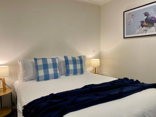 a bedroom with a bed with blue and white pillows at Donovan Guest House in Tatare