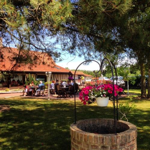 a group of people sitting at a table in a park at Hôtel Restaurant Le Fiacre à Quend plage in Quend