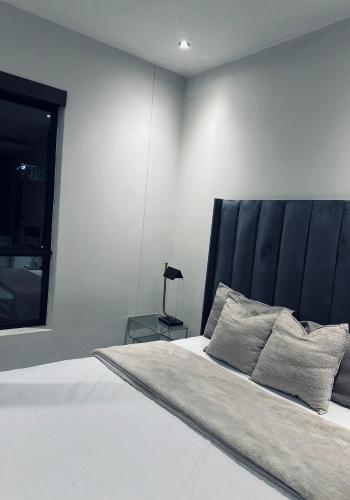 a bedroom with a large bed with a black headboard at Luxury apartment at the paramount in Johannesburg