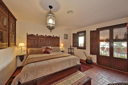 a bedroom with a large bed with a wooden headboard at Solar MontesClaros in Granada