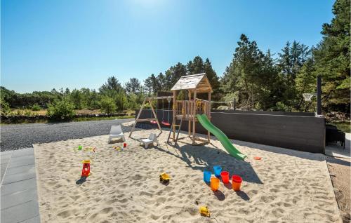 a playground in the sand next to a river at Nice Home In Blåvand With Kitchen in Blåvand