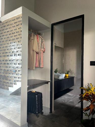 a room with a closet with a suitcase and a mirror at La Sataqui in Cansaulim
