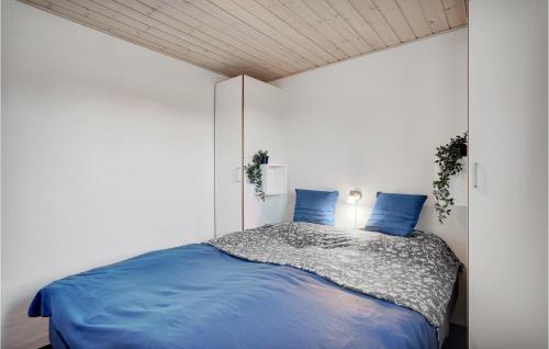 a bedroom with a bed with blue pillows on it at Amazing Home In Skjern With 5 Bedrooms, Sauna & Wifi in Skjern