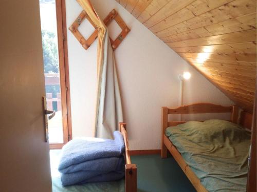 une petite chambre avec un lit et une fenêtre dans l'établissement Saint-François-Longchamp, chalet 8 pers, 3 chambres - FR-1-807-15, à Saint-François-Longchamp