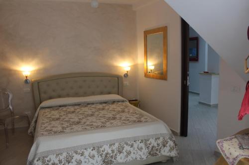 a bedroom with a bed and a mirror on the wall at B&B Xenia in Palermo
