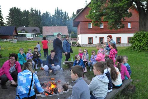 a group of people sitting around a fire at Rodinný penzion Skiland in Ostružná