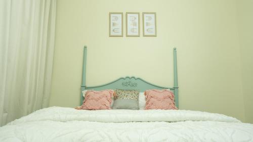 a bed with white sheets and pink pillows on it at Modern Apartment near Burj khalifa in Dubai