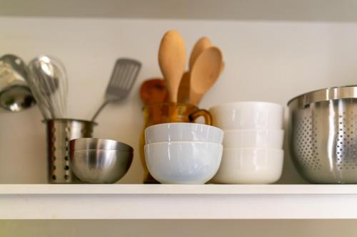 a shelf with bowls and utensils on it at Historic Sandstone Ross Farmhouse in Ross