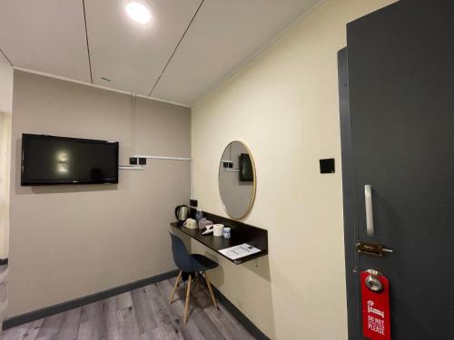 a room with a desk and a tv on the wall at CU Boutique Hotel in Kota Kinabalu