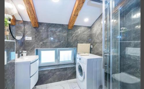 een badkamer met een wasmachine en een douche bij Apartment Punta with garage, balcony, garden and sea view in Opatija