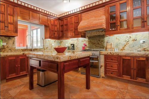 a large kitchen with wooden cabinets and a large island at 5 BD Luxury Villa with Large Pool & Minutes from Beach in Puerto Aventuras