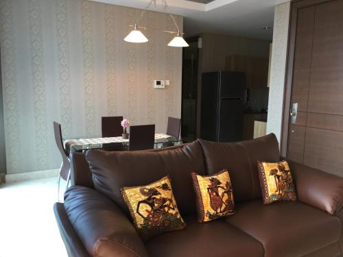 a brown couch with pillows in a living room at Signature Apartment @ The Windsor in Jakarta