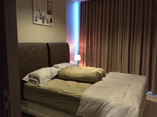 a bed in a room with a blue light at Signature Apartment @ The Windsor in Jakarta