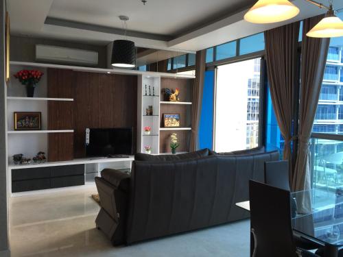 a living room with a couch and a television at Signature Apartment @ The Windsor in Jakarta