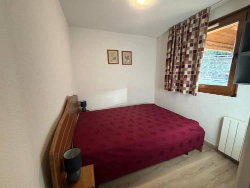 - une chambre avec un lit rouge et une fenêtre dans l'établissement Appartement 2 pièces calme avec parking aux Angles - FR-1-593-119, aux Angles