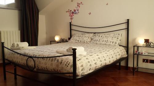 1 dormitorio con 1 cama con sábanas y almohadas blancas en Silvia, en Sarzana
