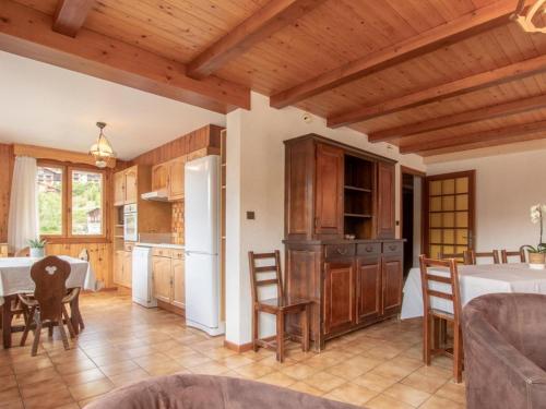 une cuisine et une salle à manger avec une table et des chaises dans l'établissement Appart 9 pers. avec Sauna et Spa au pied des pistes, parking privé - FR-1-467-142, au Grand-Bornand