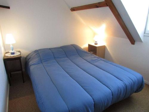 - un lit bleu dans une chambre avec deux lampes dans l'établissement Maisonnette avec piscine et animaux admis proche plage à Erdeven - FR-1-479-170, à Erdeven