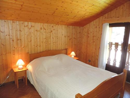 - une chambre avec un lit et 2 tables avec des lampes dans l'établissement Appartement spacieux avec sauna et spa, proche des pistes - FR-1-467-143, au Grand-Bornand