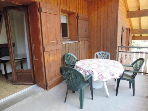 un patio avec une table et des chaises sur un balcon dans l'établissement Appartement spacieux avec sauna et spa, proche des pistes - FR-1-467-143, au Grand-Bornand
