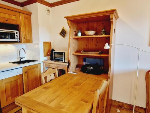 une cuisine avec une table en bois et un micro-ondes dans l'établissement Charmant appartement 4 pers au pied des pistes, animaux admis - FR-1-755-36, à Aime La Plagne