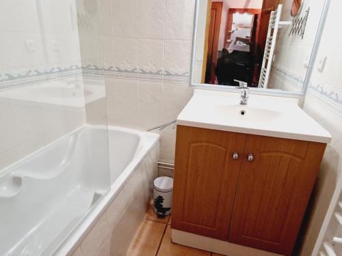 une salle de bain avec un lavabo, une baignoire et un miroir dans l'établissement Charmant appartement 4 pers au pied des pistes, animaux admis - FR-1-755-36, à Aime La Plagne