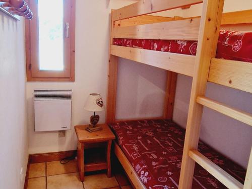 - une chambre avec 2 lits superposés et une table avec une lampe dans l'établissement Charmant appartement 4 pers au pied des pistes, animaux admis - FR-1-755-36, à Aime La Plagne