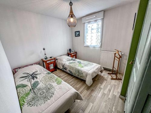 une chambre avec deux lits et une fenêtre dans l'établissement Appartement 3 pièces à Étel avec jardin, wifi et parking privé - FR-1-479-172, à Étel