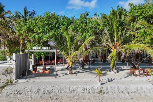 a restaurant on the beach with palm trees at WAVE SOUND by 3S Maldives in Maradhoofeydhoo