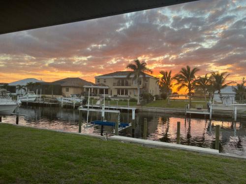 a sunset over a marina with houses and boats at WATER WATER WATER - newly renovated 3BR, 2 bath canal front home in Punta Gorda Isles in Punta Gorda
