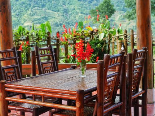 a wooden table with a vase of flowers on a porch at Lee's Charm Homestay in Sa Pa