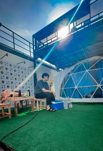 a man sitting at a table in a tent at อินทนนท์แคมป์ปิ้ง เขื่อนสิรินธร in Sirindhorn