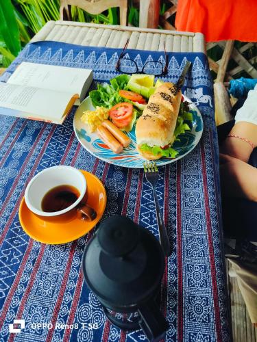 a plate with a sandwich and vegetables and a cup of coffee at Tulip Resort Pai in Pai