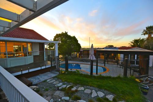 a house with a fence and a swimming pool at Holiday house in totara park in Auckland