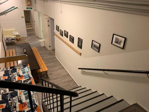 a staircase in a building with pictures on the wall at Wanha Koulu Tahko Onnela, 4mh, Palju, Sauna, Tupakeittiö, Wifi, Liikuntasali, RinteetSpaRavintola 6km, Lemmikit OK, Edukas in Reittiö