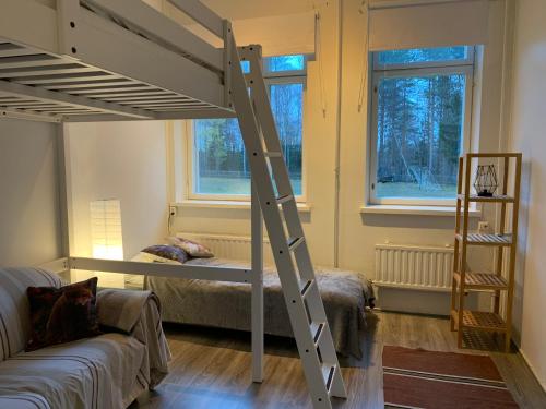 a room with a bunk bed and two windows at Wanha Koulu Tahko Onnela, 4mh, Palju, Sauna, Tupakeittiö, Wifi, Liikuntasali, RinteetSpaRavintola 6km, Lemmikit OK, Edukas in Reittiö