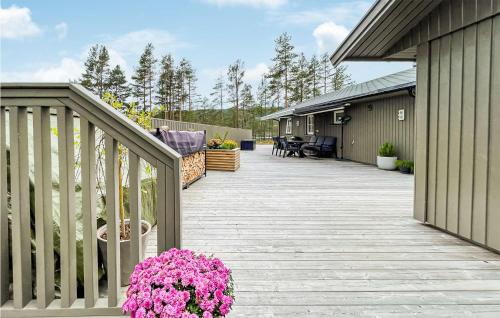 a wooden deck with pink flowers on a house at Nice Home In Nissedal With Lake View in Kyrkjebygdi