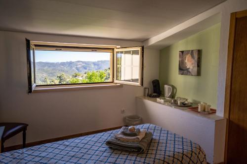 a small room with a bed and a window at Raposeira Bed & Breakfast in Maçãs de Dona Maria