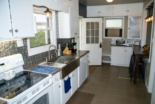 a kitchen with white cabinets and a sink at My Home Is Your Home home in Grand Junction