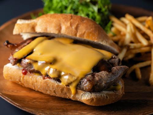 a sandwich on a plate with cheese and fries at Yunoyado Mochizuki in Myoko