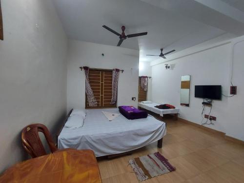 ein Zimmer mit einem Bett und einem Tisch darin in der Unterkunft Rajlaxmi Resort - Pure Veg in Bolpur