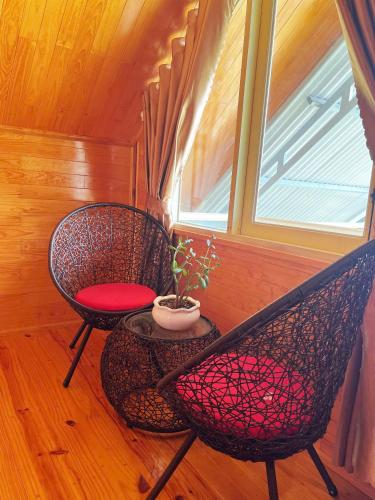 two chairs and a table in a room with a window at Homestay Nhà Xinh in Xuân Trường