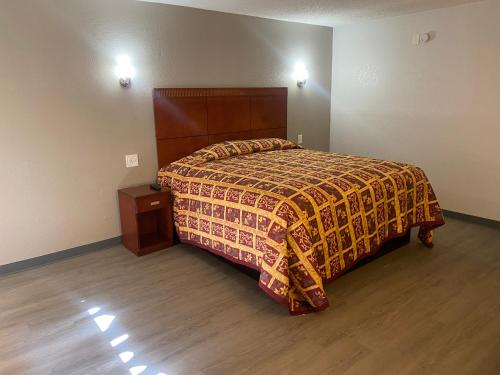 a bedroom with a bed and a wooden floor at American Inn and Suites - Atlanta Airport Jonesboro I-75 in Jonesboro