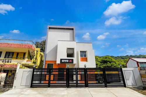 a white building with a gate in front of it at Hotel O Elegant Residency Vandalur Zoo in Chennai