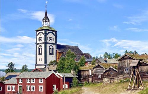 a church with a tower with a clock on it at 3 Bedroom Cozy Home In Røros in Røros