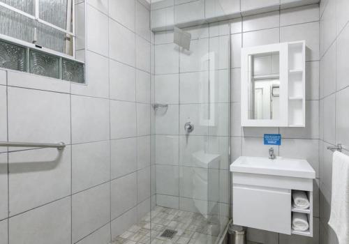 a white bathroom with a toilet and a sink at Shaka Shores 7E in Durban