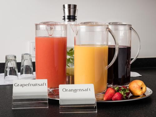 two glasses of different types of juice on a table at Hotel Deutsches Haus in Bonn